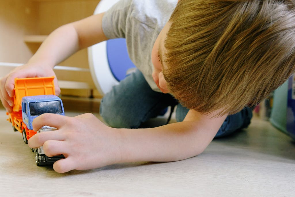 BOY PLAYING WITH TOY TRUCKS