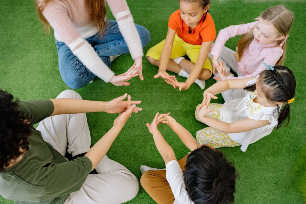 PRESCHOOL CHILDREN DOING HAND EXERCISE WITH TEACHERS