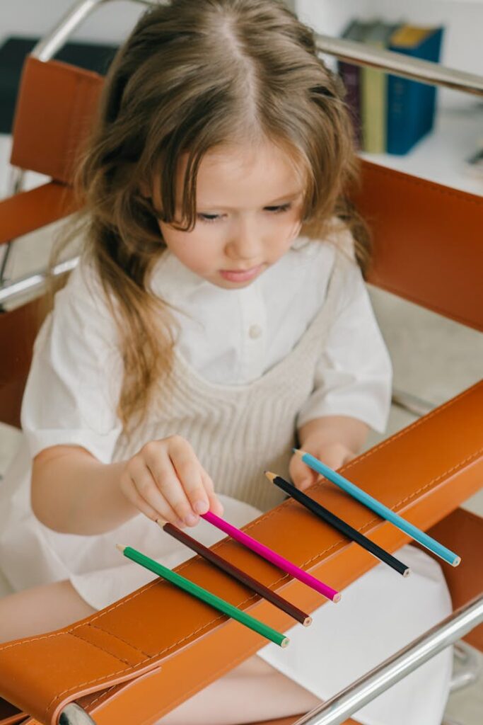 AUTISM SERVICES PHOTOGRAPH OF A GIRL ARRANGING COLORED PENCILS